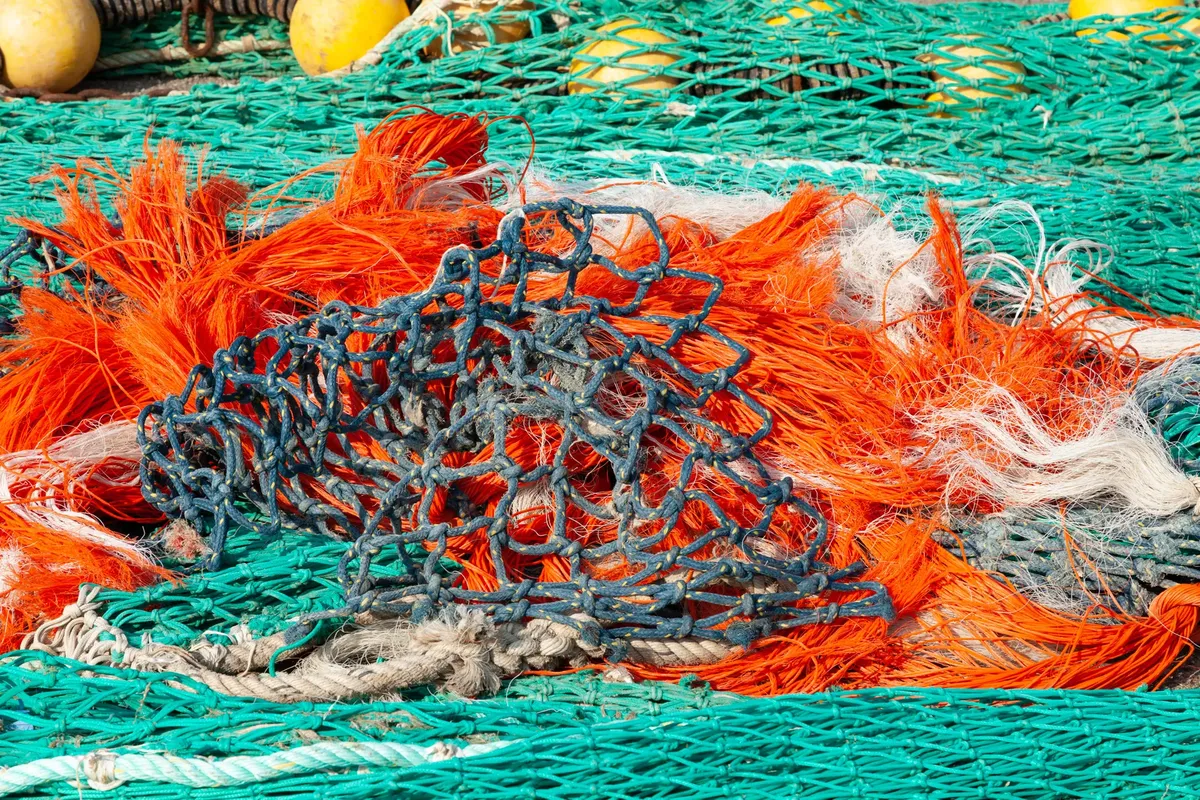 Vibrant fishing nets tangled together in Guilvinec, France, showcasing marine industry.